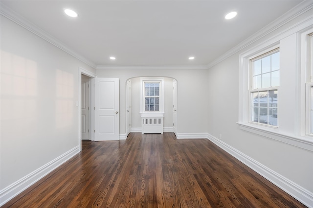 empty room featuring crown molding, dark hardwood / wood-style floors, and radiator