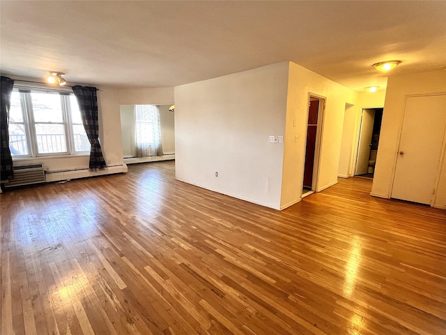 spare room featuring hardwood / wood-style flooring and an AC wall unit