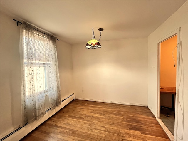 unfurnished dining area featuring baseboard heating and wood-type flooring