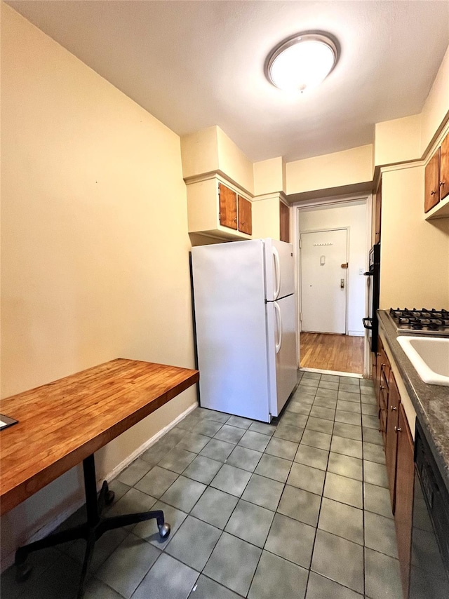 kitchen with sink, black dishwasher, white refrigerator, and double oven