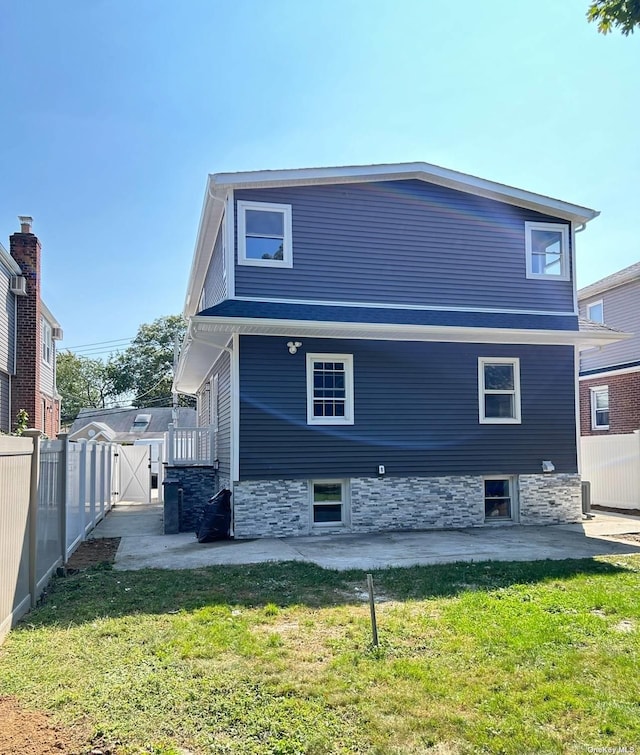 rear view of property with a yard and a patio