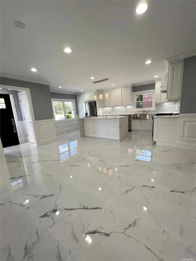 kitchen featuring backsplash, white cabinetry, hanging light fixtures, stainless steel fridge with ice dispenser, and ornamental molding