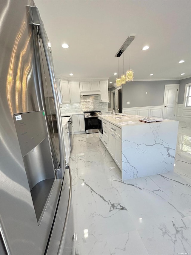 kitchen with white cabinetry, appliances with stainless steel finishes, pendant lighting, light stone counters, and a center island