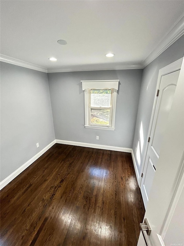 empty room featuring ornamental molding and dark hardwood / wood-style floors