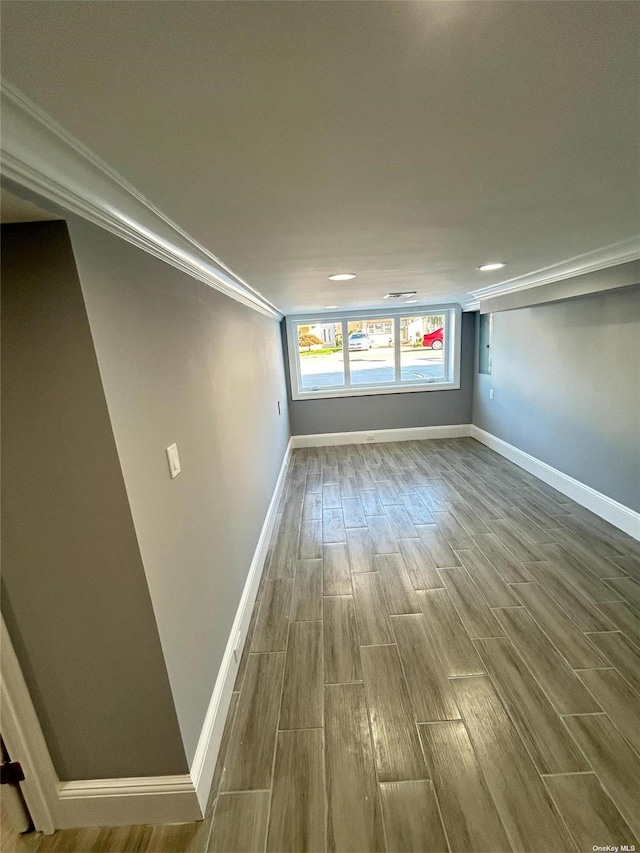 spare room with ornamental molding and wood-type flooring