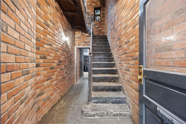 stairs featuring brick wall