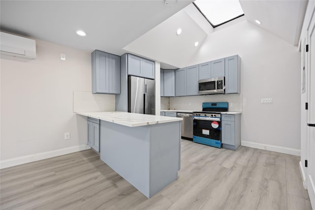 kitchen featuring an AC wall unit, appliances with stainless steel finishes, kitchen peninsula, light wood-type flooring, and high vaulted ceiling