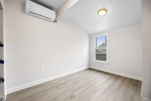 spare room with light hardwood / wood-style floors, vaulted ceiling with beams, and a wall mounted air conditioner