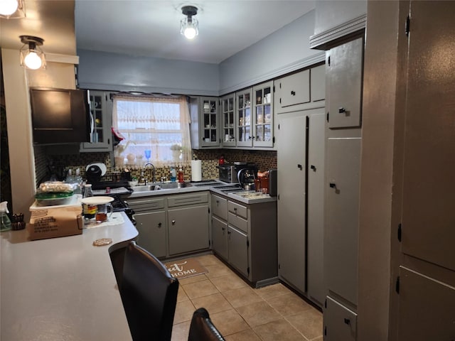 kitchen with sink, backsplash, gray cabinets, and light tile patterned flooring