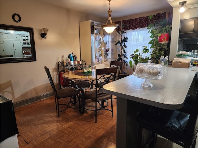 dining area featuring dark parquet flooring