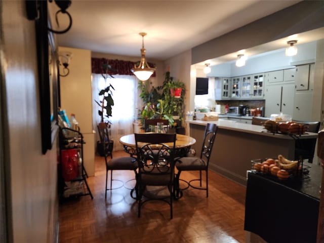 dining space featuring dark parquet floors