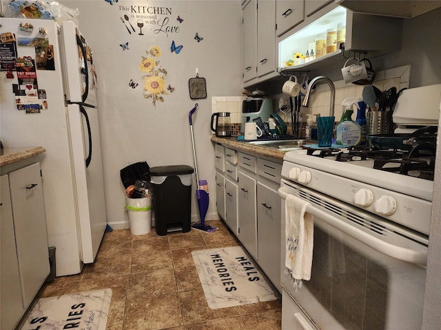 kitchen featuring backsplash, sink, and white appliances