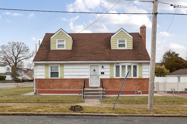 cape cod house with a front lawn