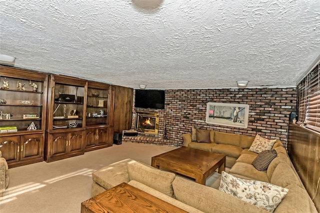 carpeted living room featuring a brick fireplace, a textured ceiling, and brick wall