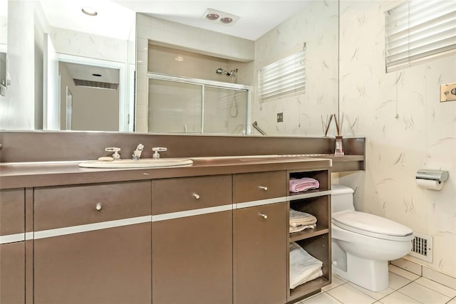 bathroom with toilet, tile patterned floors, a shower with door, and vanity