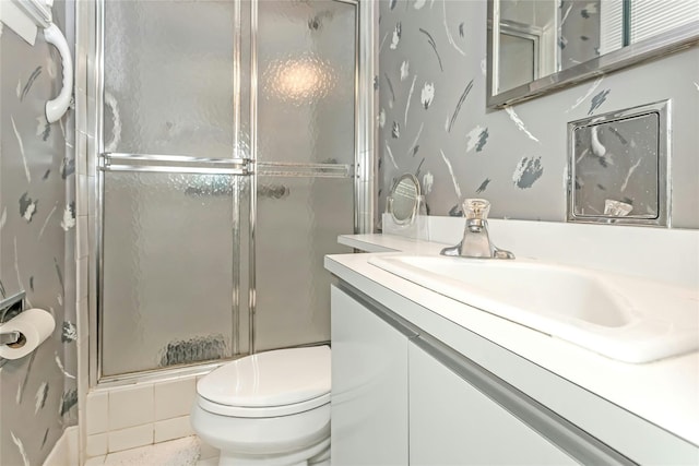 bathroom featuring an enclosed shower, vanity, and toilet