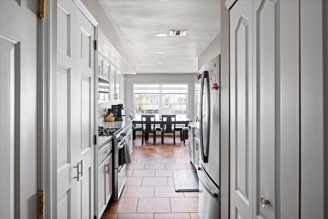 kitchen with white cabinetry, light tile patterned floors, and appliances with stainless steel finishes