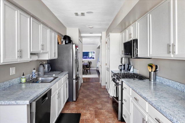 kitchen featuring white cabinets, dishwasher, range with two ovens, and sink