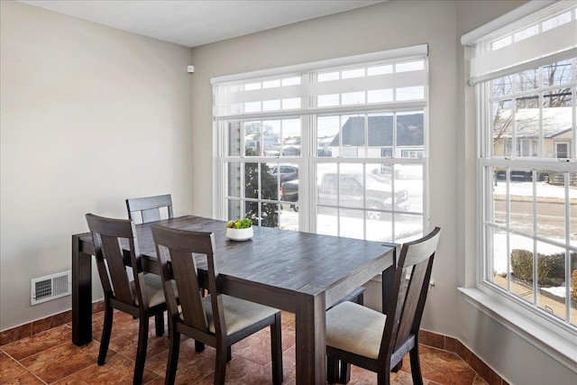 dining area featuring dark tile patterned floors