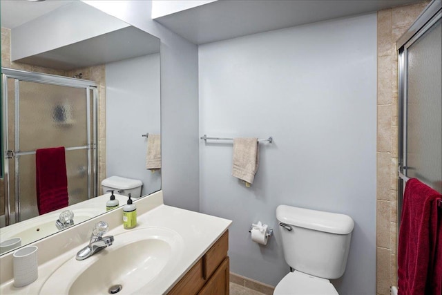 bathroom featuring toilet, an enclosed shower, and vanity