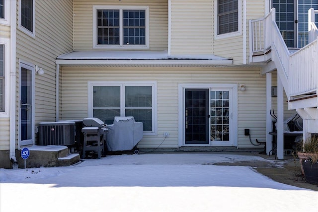 snow covered house with central air condition unit