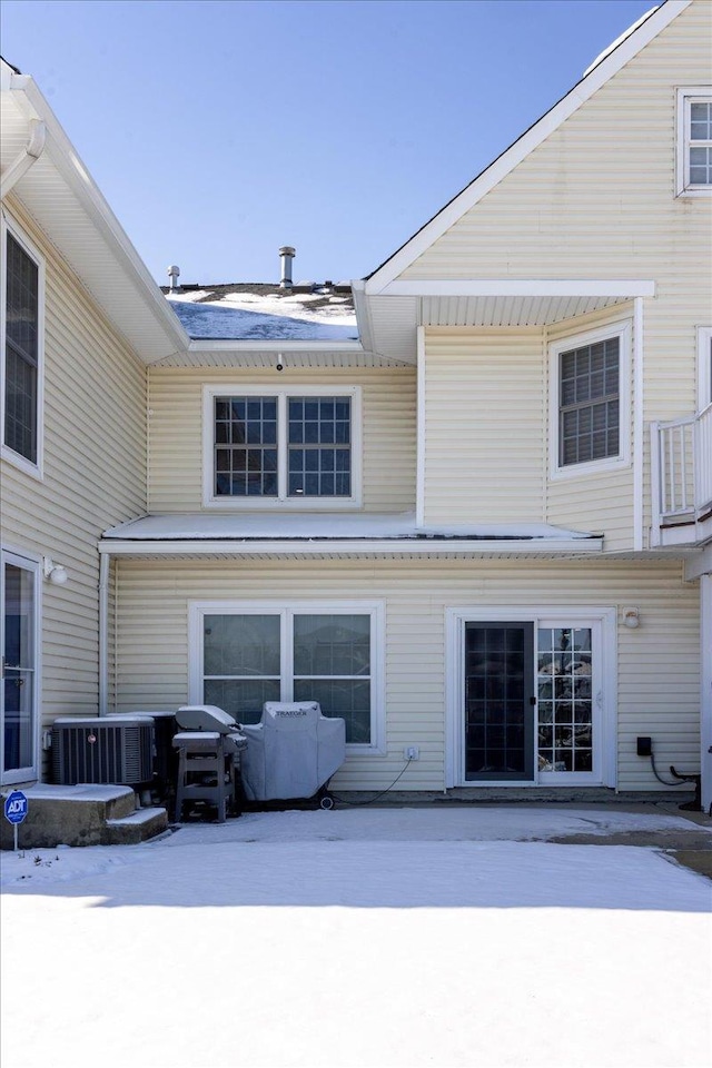 snow covered property featuring central AC unit