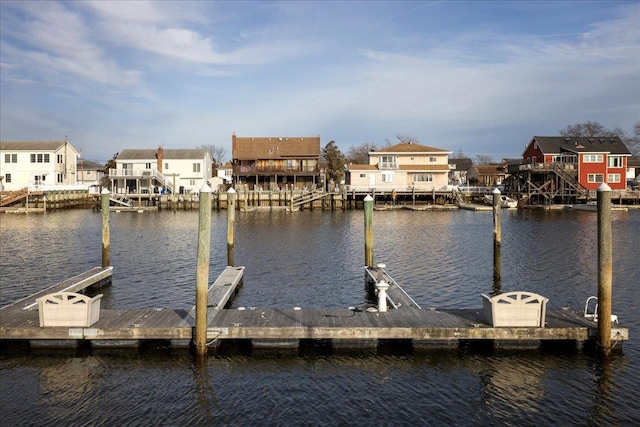 view of dock with a water view and a residential view