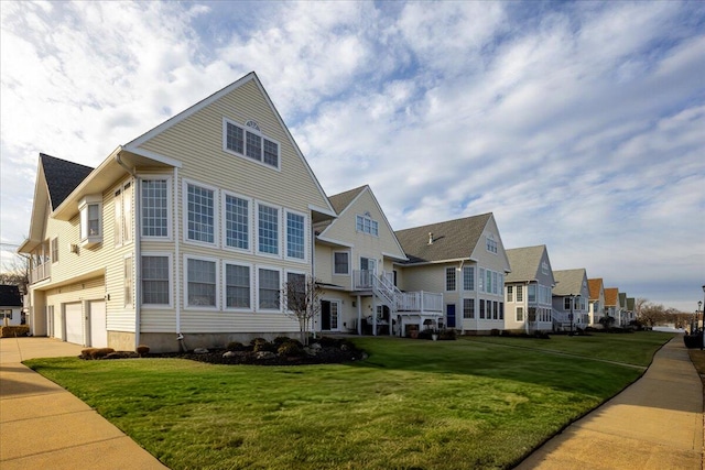 view of front of house featuring a garage, driveway, a residential view, and a front lawn