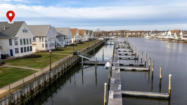 dock area with a residential view, a water view, and a lawn