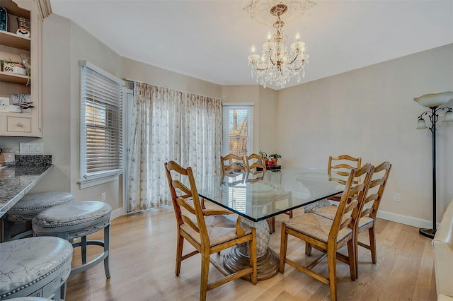 dining space with a notable chandelier and light wood-type flooring