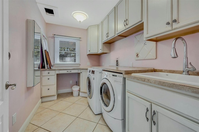 laundry area with cabinets, sink, washing machine and dryer, and light tile patterned floors