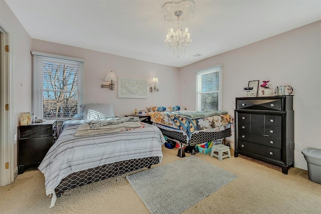 bedroom with multiple windows, a notable chandelier, and light colored carpet