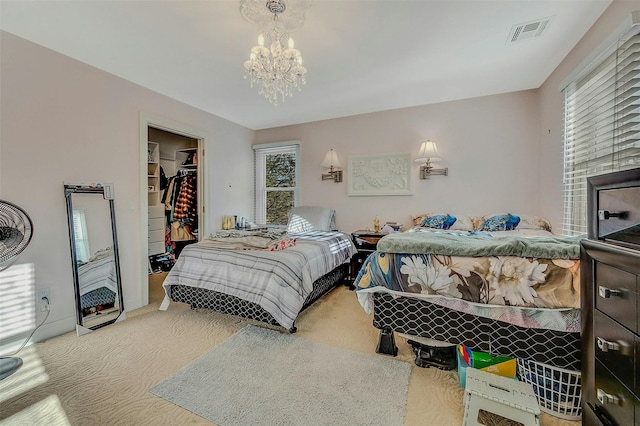 bedroom featuring multiple windows, a spacious closet, a closet, and a notable chandelier