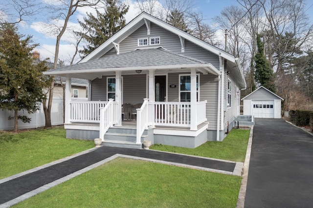 bungalow-style house with a front lawn, covered porch, an outdoor structure, and a garage