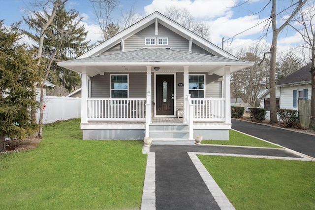 bungalow-style home featuring covered porch and a front lawn