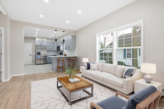 living room with light hardwood / wood-style flooring and sink