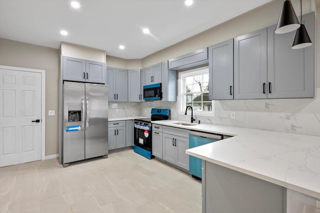 kitchen with decorative light fixtures, decorative backsplash, sink, light stone countertops, and stainless steel appliances