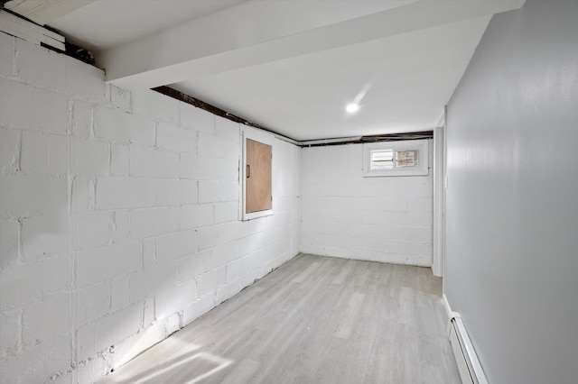 basement with baseboard heating and light hardwood / wood-style flooring