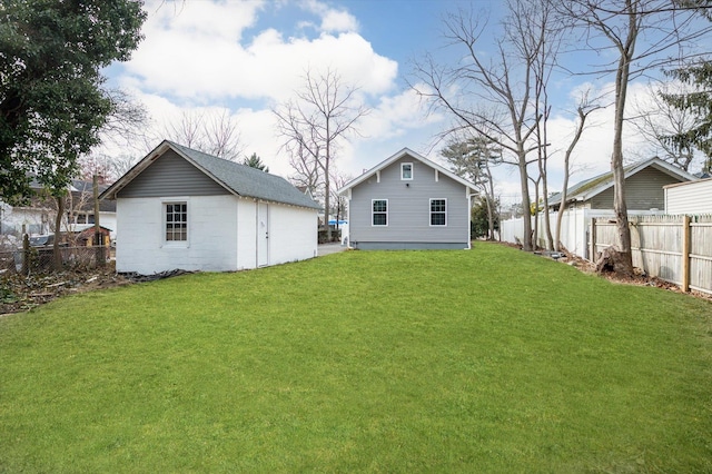 back of house with an outbuilding and a yard