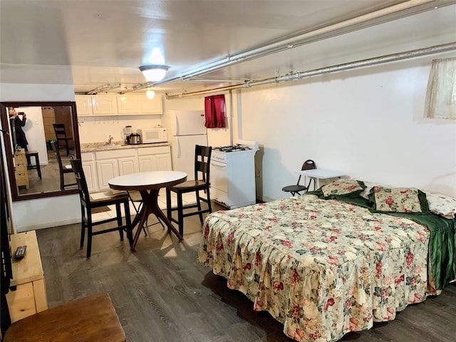 bedroom featuring dark wood-type flooring, sink, and white fridge