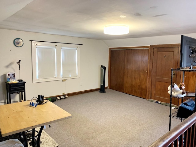 home office with lofted ceiling and light carpet