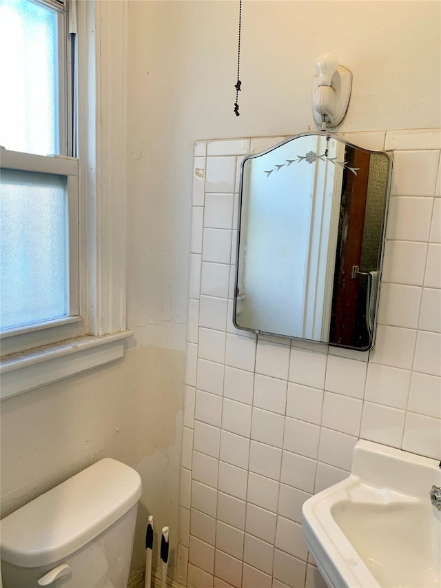 bathroom with sink, tile walls, toilet, and tasteful backsplash