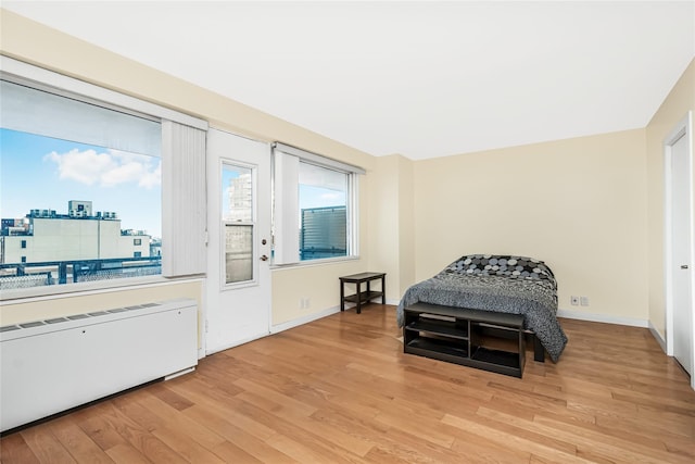 bedroom with light wood-type flooring and radiator heating unit