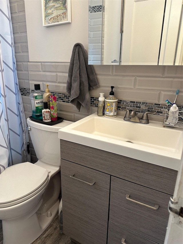 bathroom with toilet, decorative backsplash, and vanity