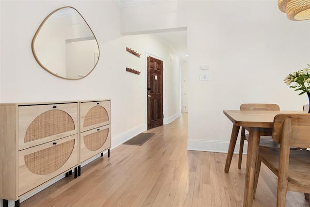 hallway featuring crown molding and light hardwood / wood-style floors