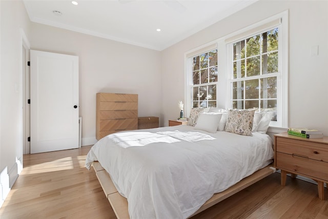 bedroom featuring ornamental molding and light hardwood / wood-style flooring