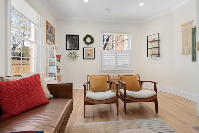 sitting room featuring crown molding and light hardwood / wood-style flooring