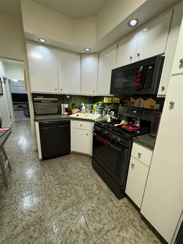 kitchen with sink, white cabinetry, backsplash, and black appliances