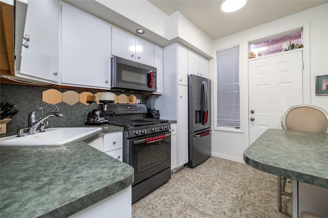 kitchen with dark countertops, appliances with stainless steel finishes, and white cabinets