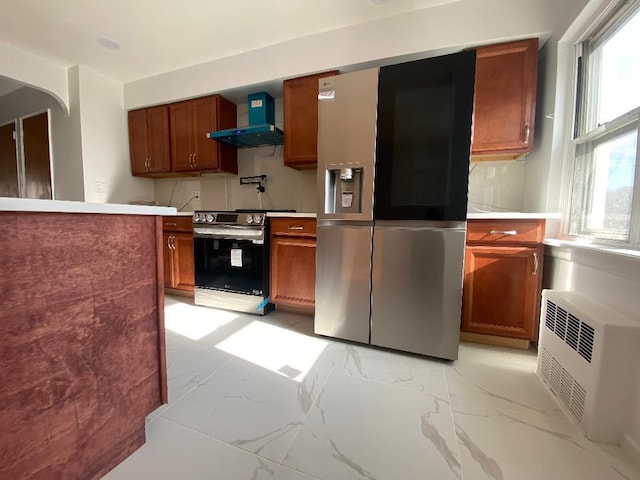 kitchen with appliances with stainless steel finishes and wall chimney exhaust hood